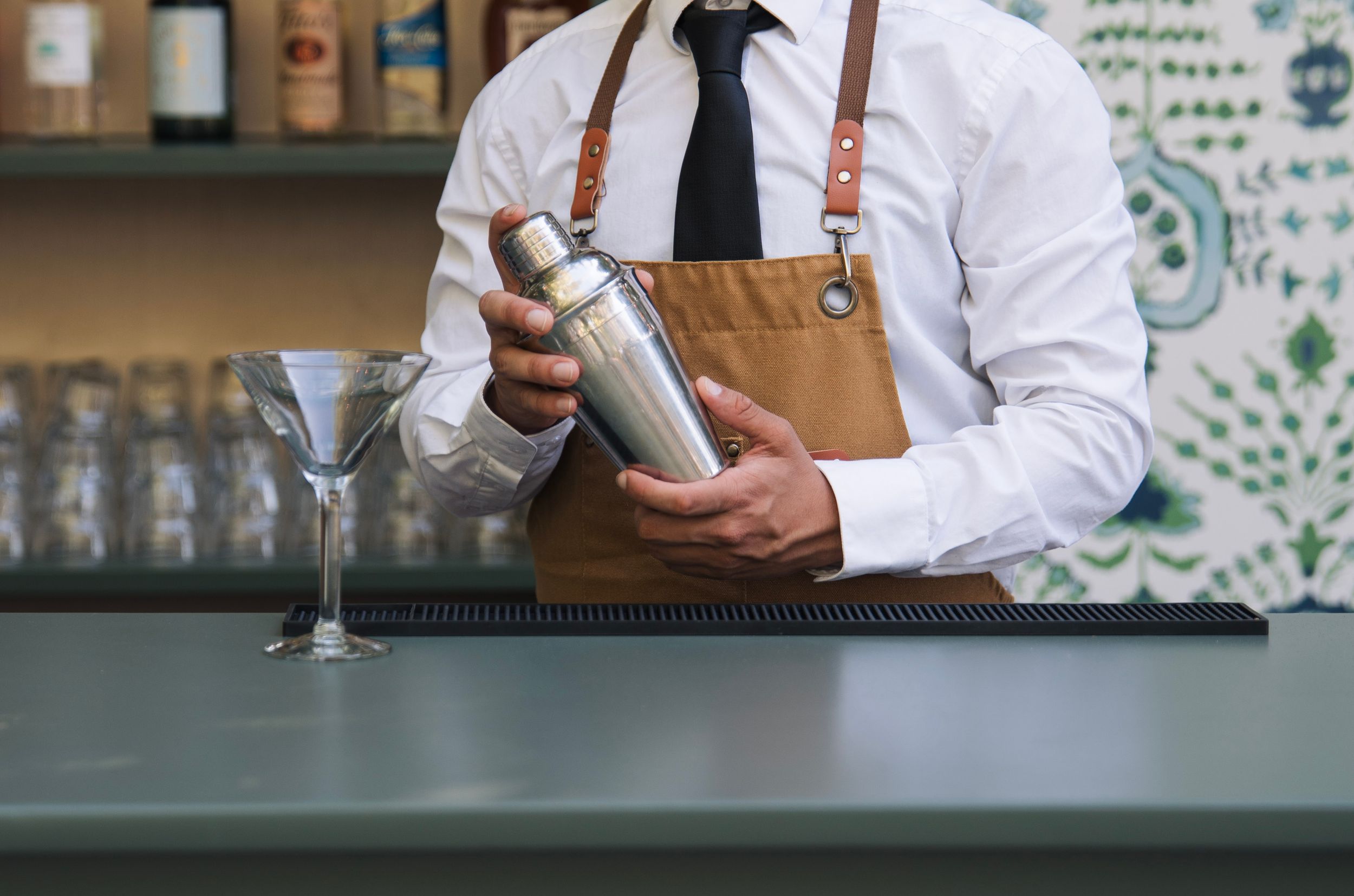 Front torso of a man shaking a margarita mixer at the bar, showcasing the catering companies bar