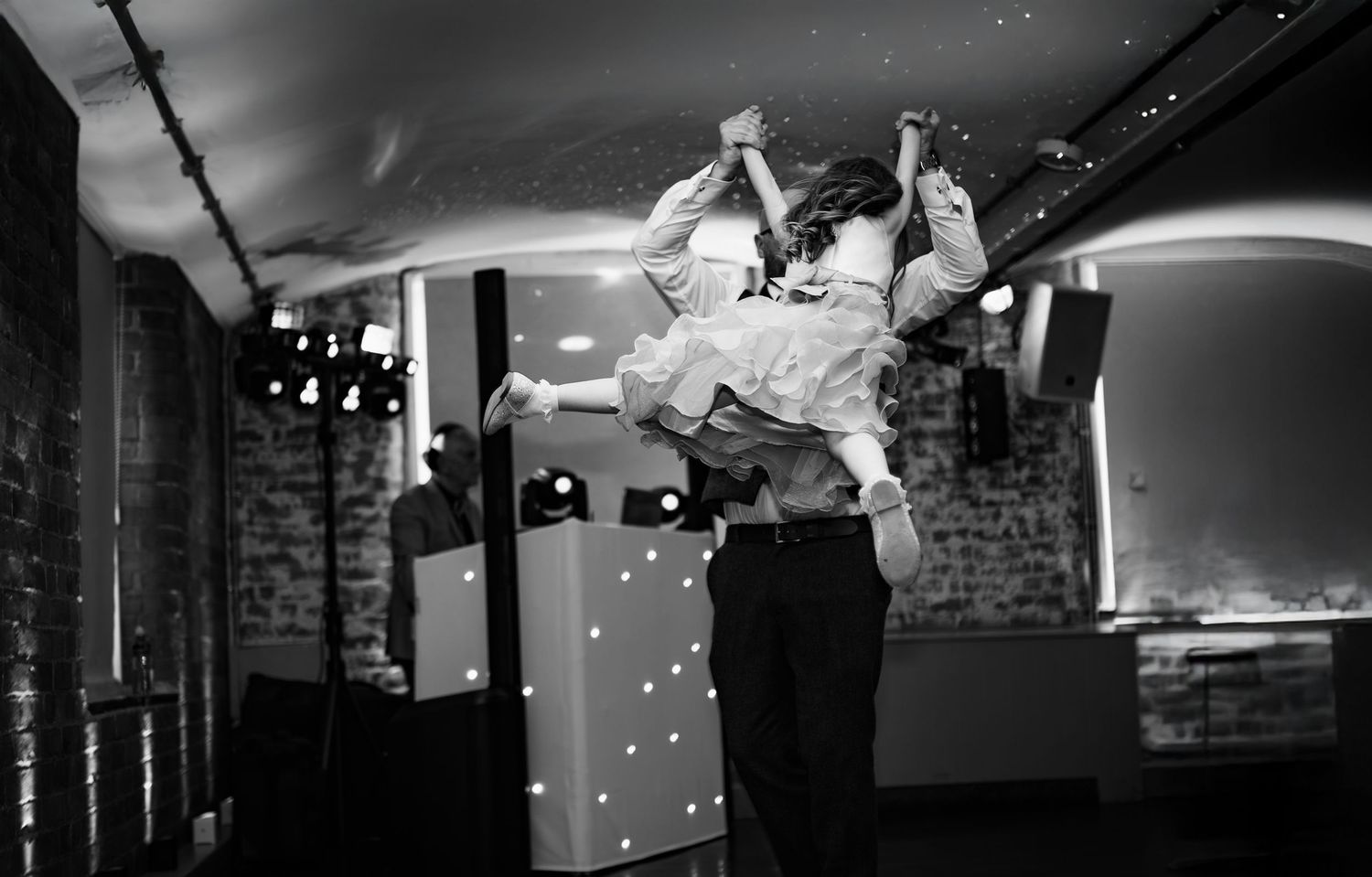 Joyful wedding guests dancing on the first floor of The West Mill Derbyshire wedding venue