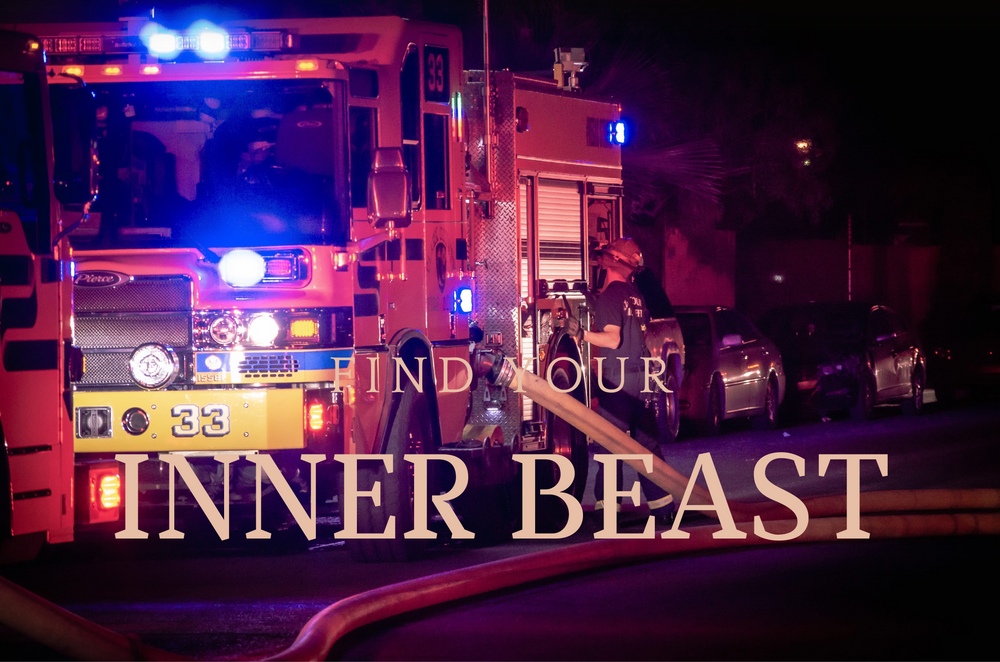 Fire truck with emergency lights illuminating text reading 'Find Your Inner Beast' at night.