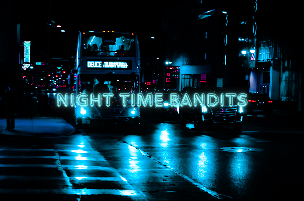 City street at night with blue reflections from neon lights on wet pavement.