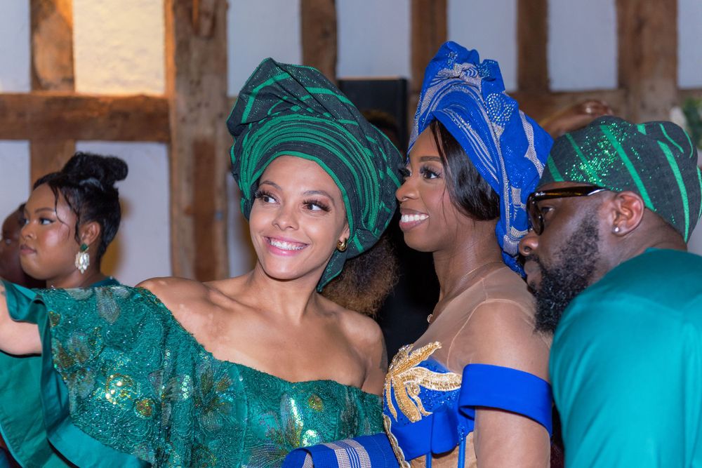 Wedding guests in colorful attire enjoying celebration at indoor venue.
