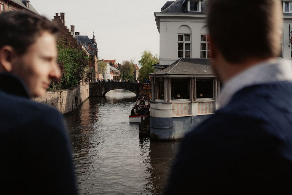 View of a canal in Bruges with historic buildings and boats along the waterway.
