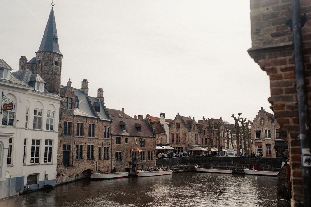 Medieval architecture and historic buildings along a peaceful canal in Bruges.