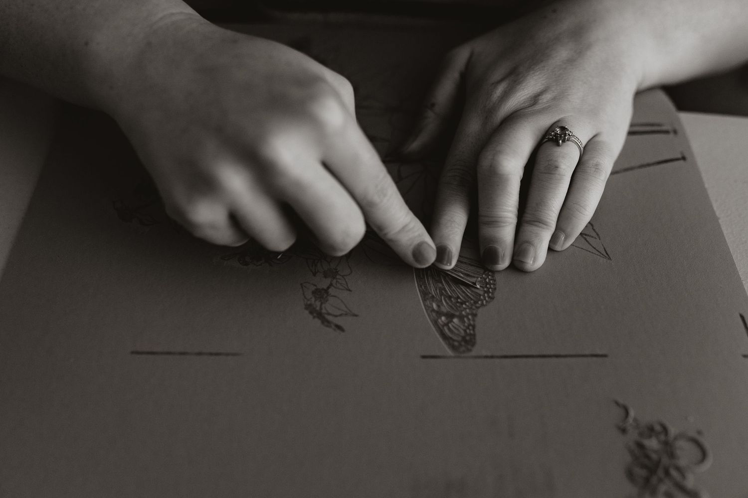 Hands holding pencils write on paper while working on multiple documents spread across a desk surface. Whitney Popp, Arizona photographer.