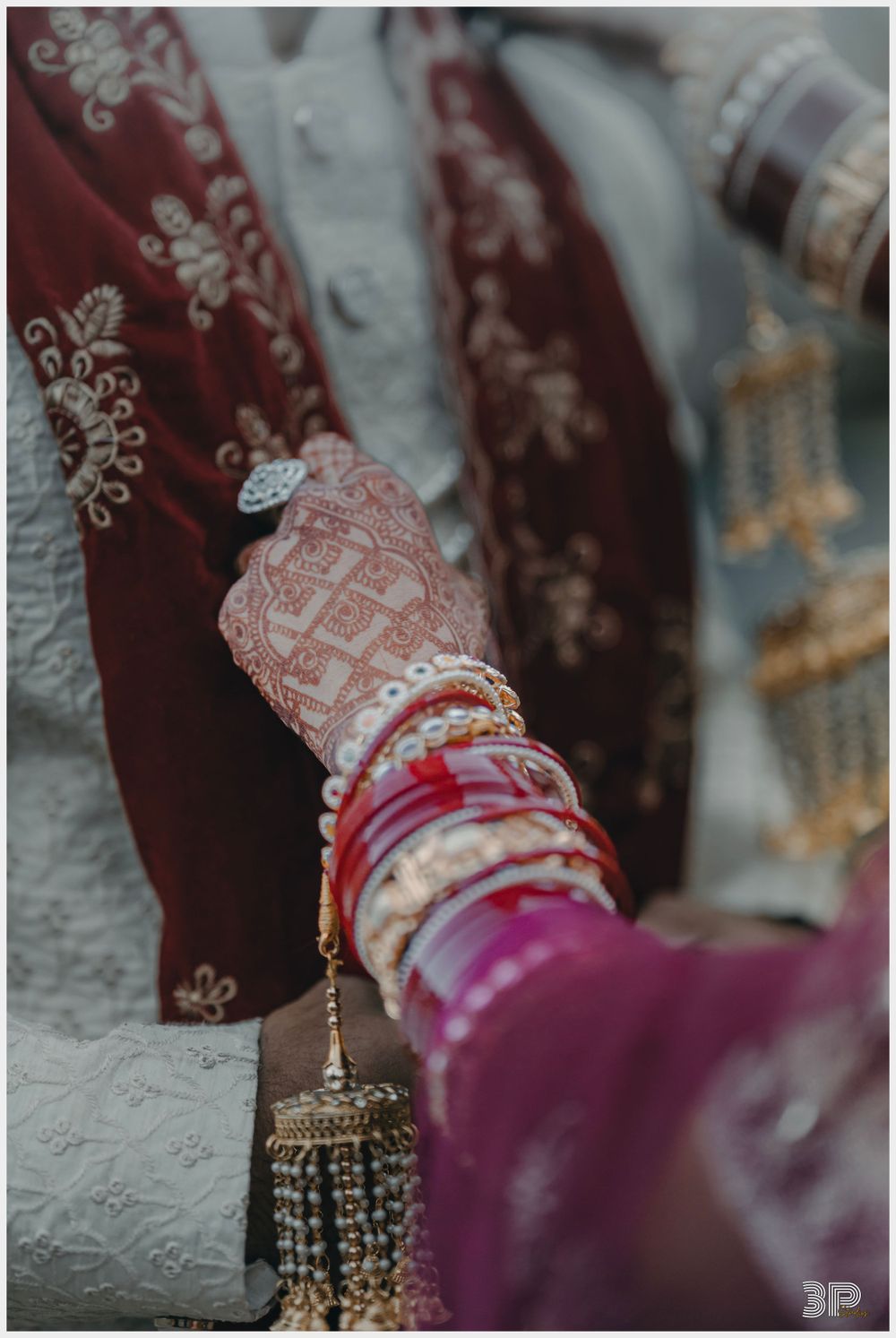 Close-up of decorated hands with traditional Indian bridal bangles and jewelry.