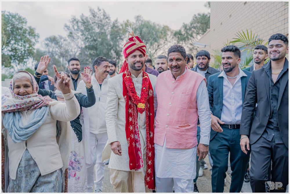 A celebratory moment at an outdoor Indian wedding with guests in traditional and modern attire.