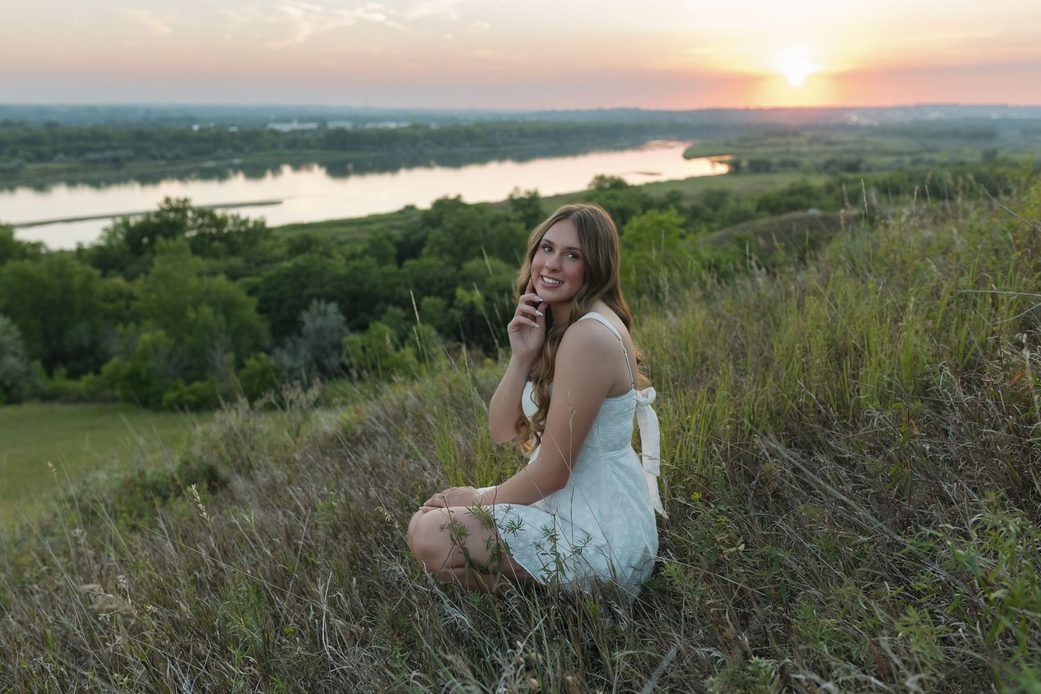 Senior portrait of a high school student on a dock during sunset in Garrison ND with golden hour lighting