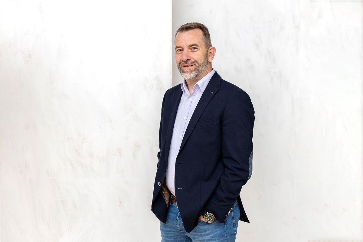 professionelles Bewerbungsfoto eines Mannes lässig mit Händen in den Hosentaschen mit blauem Sakko und Jeans im Fotostudio Bad Arolsen