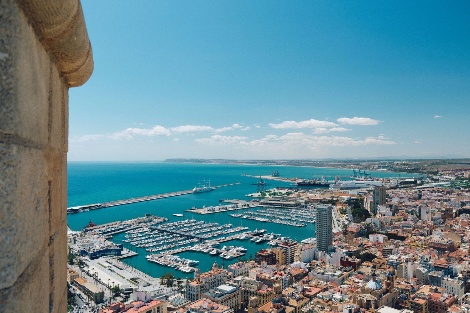 Aerial view of Alicante's marina and port with boats and Mediterranean waters.