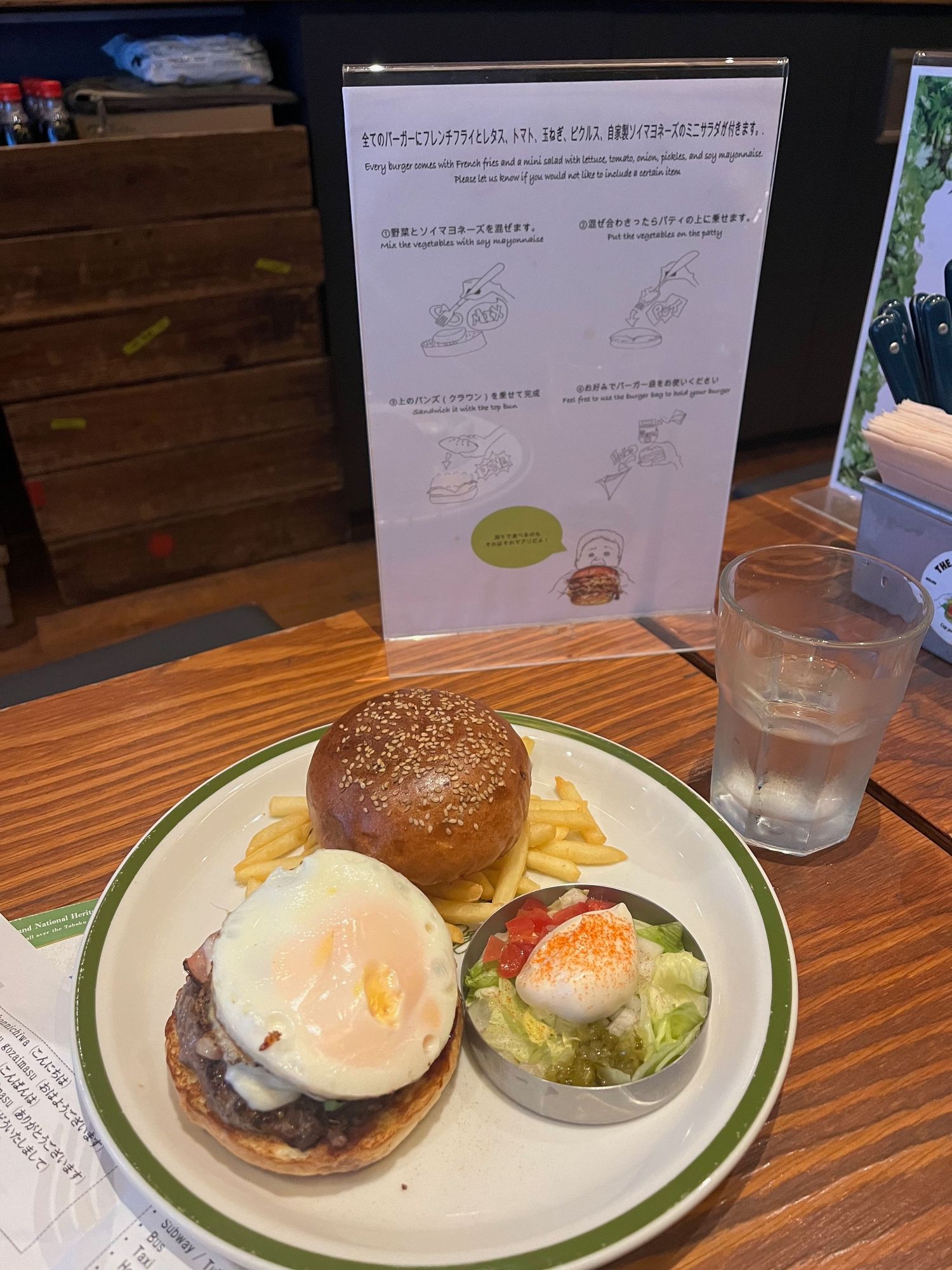 Hamburger plates with sunny side up eggs served on white plates with green trim.