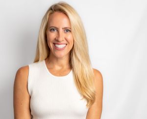 Professional studio portraits in a white sleeveless top with natural lighting.