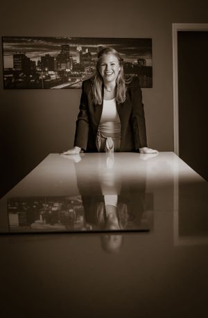 Dramatic black and white portraits at a conference table with cityscape artwork.