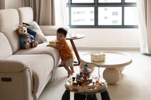Cozy living room interior with beige sofa, round coffee tables and toys.