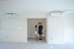 Empty white room interior with two air conditioning units mounted on the walls.