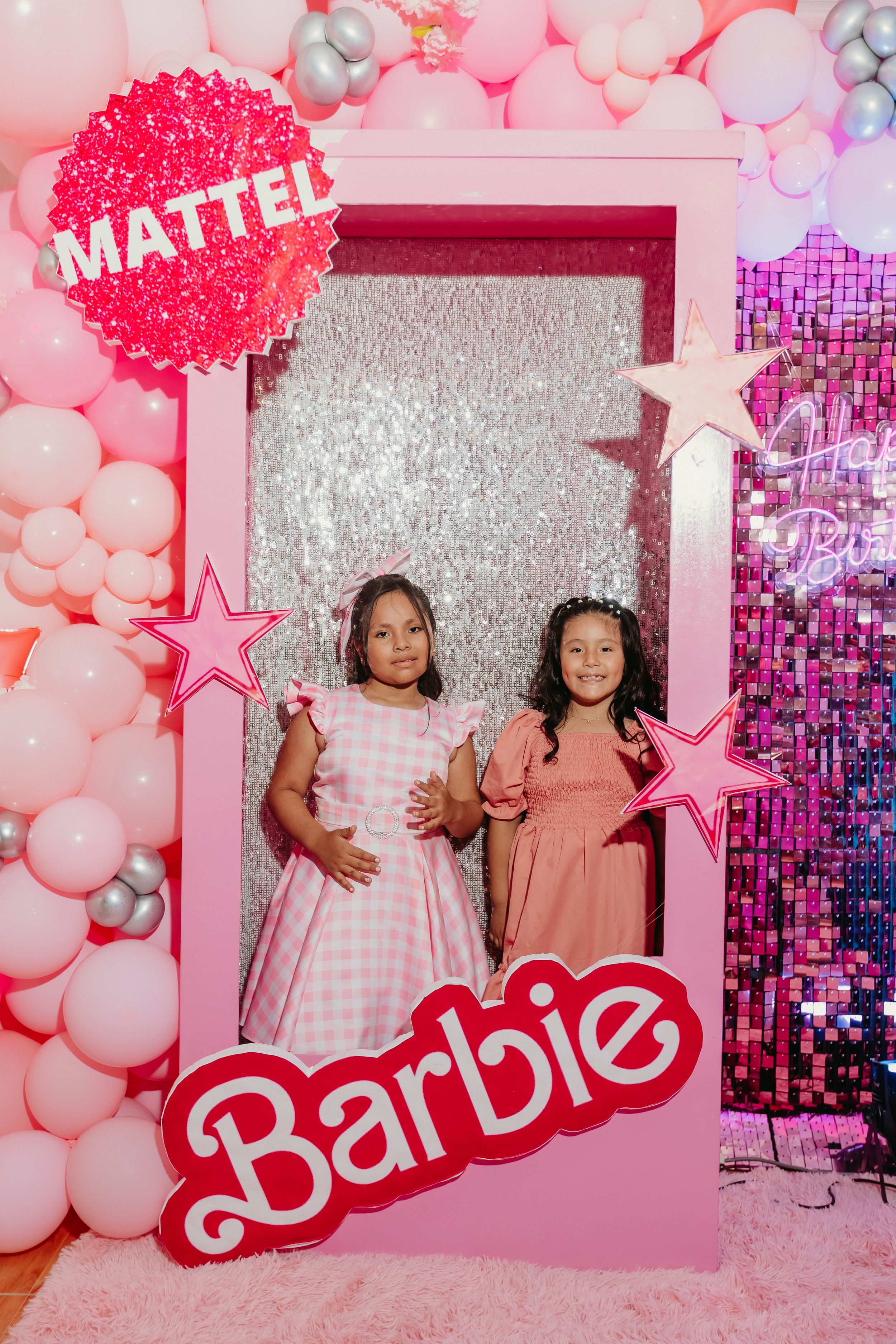 Pink Barbie-themed photo booth with Mattel branding and balloon decorations.