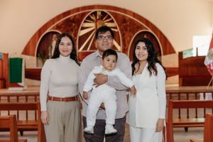 Intimate gathering inside a church with wooden pews and decorative arched wall.
