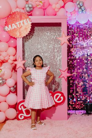 Pink Barbie-themed photo area with sparkly backdrop, stars, and balloon decorations.