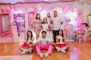 A festive pink-themed birthday party setup with balloons and decorations featuring a Barbie theme.