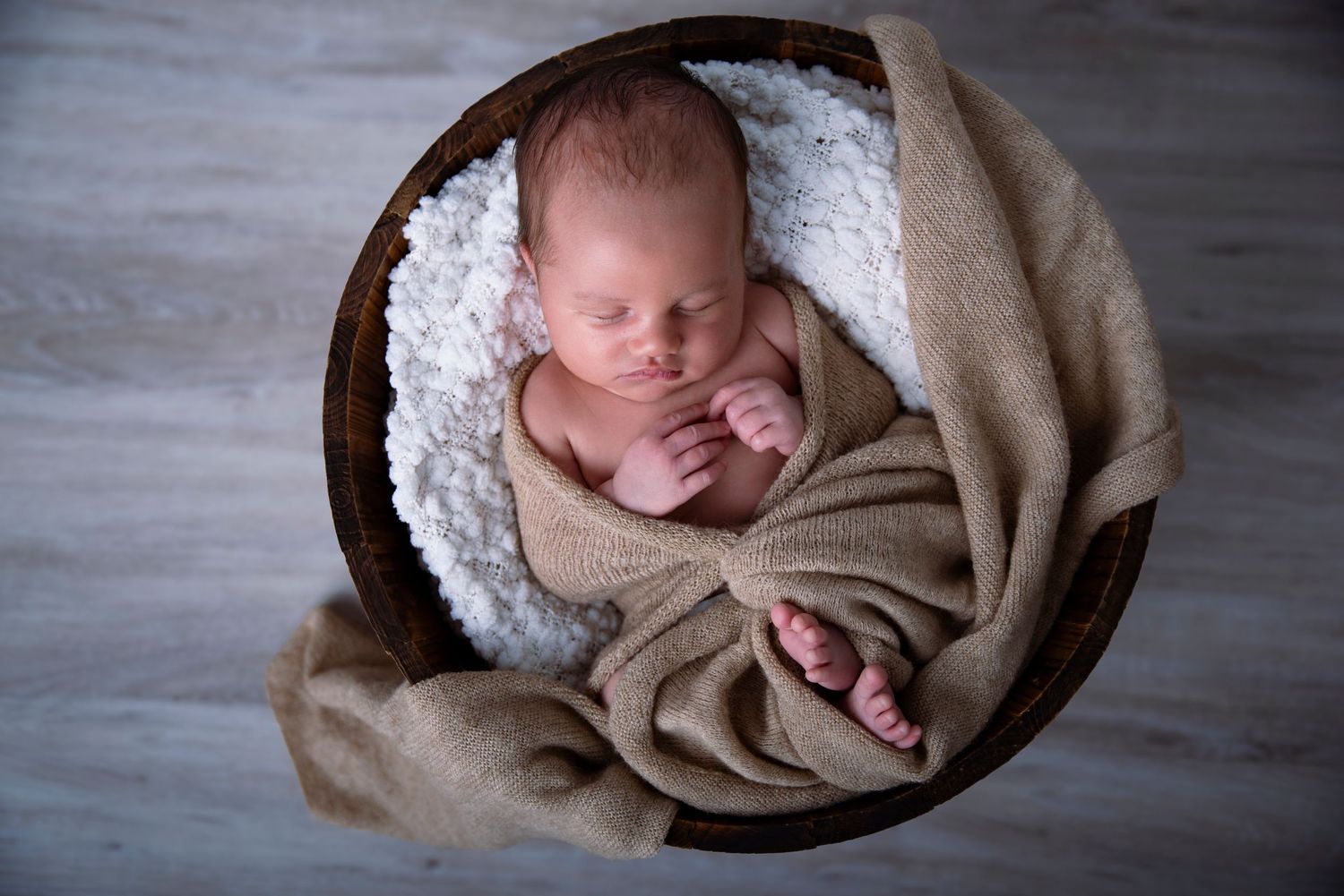 Newborn photographer Gold Coast safely posing baby in neutral wrap.