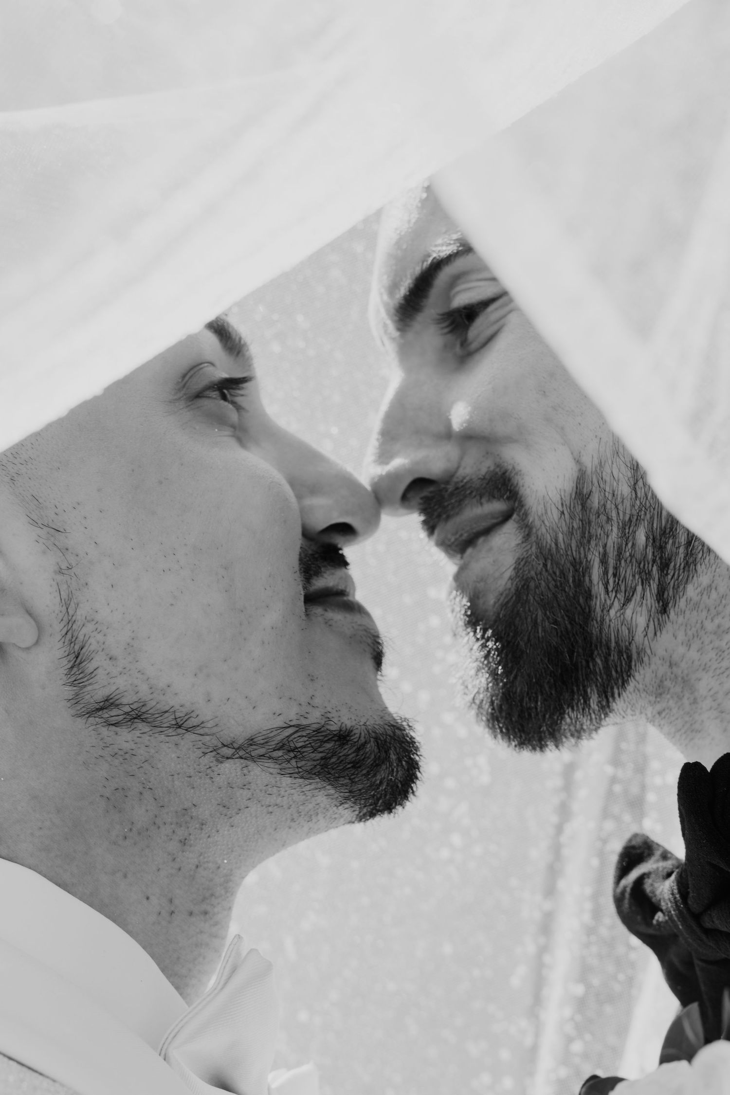 Intimate black and white portrait of couple about to kiss.