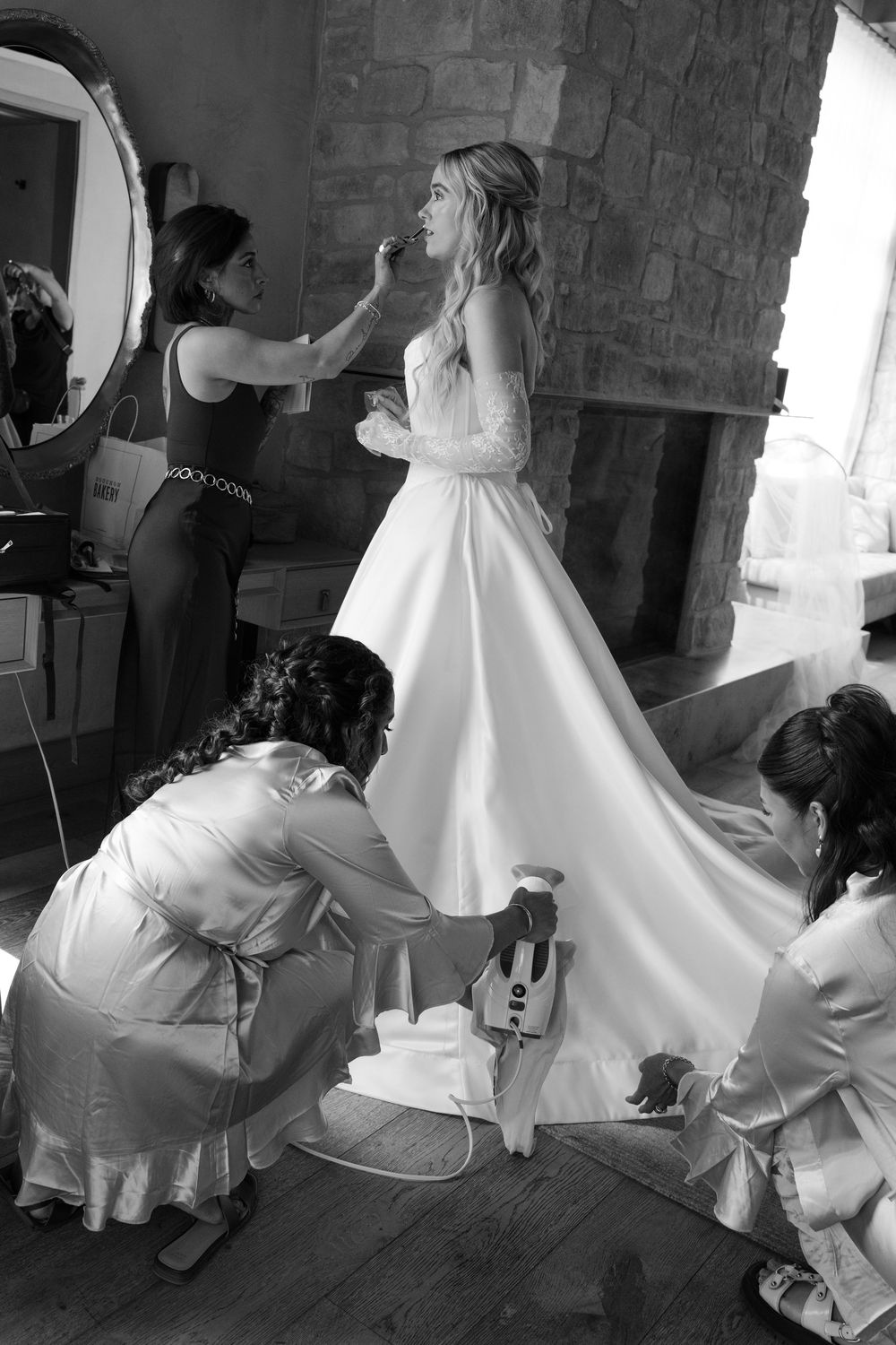 Wedding preparation scene showing the bustling of a white bridal gown.