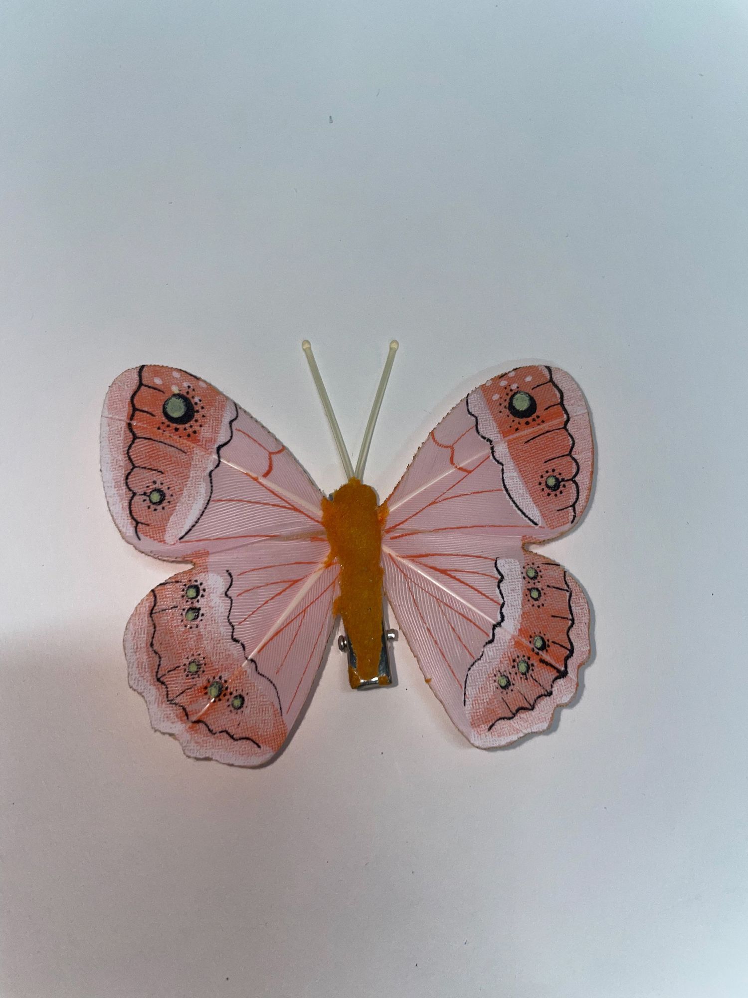 A decorative pink butterfly with detailed wing patterns and antennae.