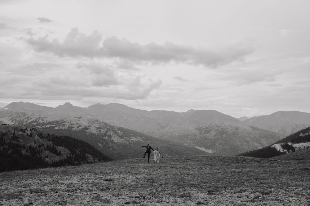A romantic black and white mountain vista features a couple silhouetted against rolling peaks.