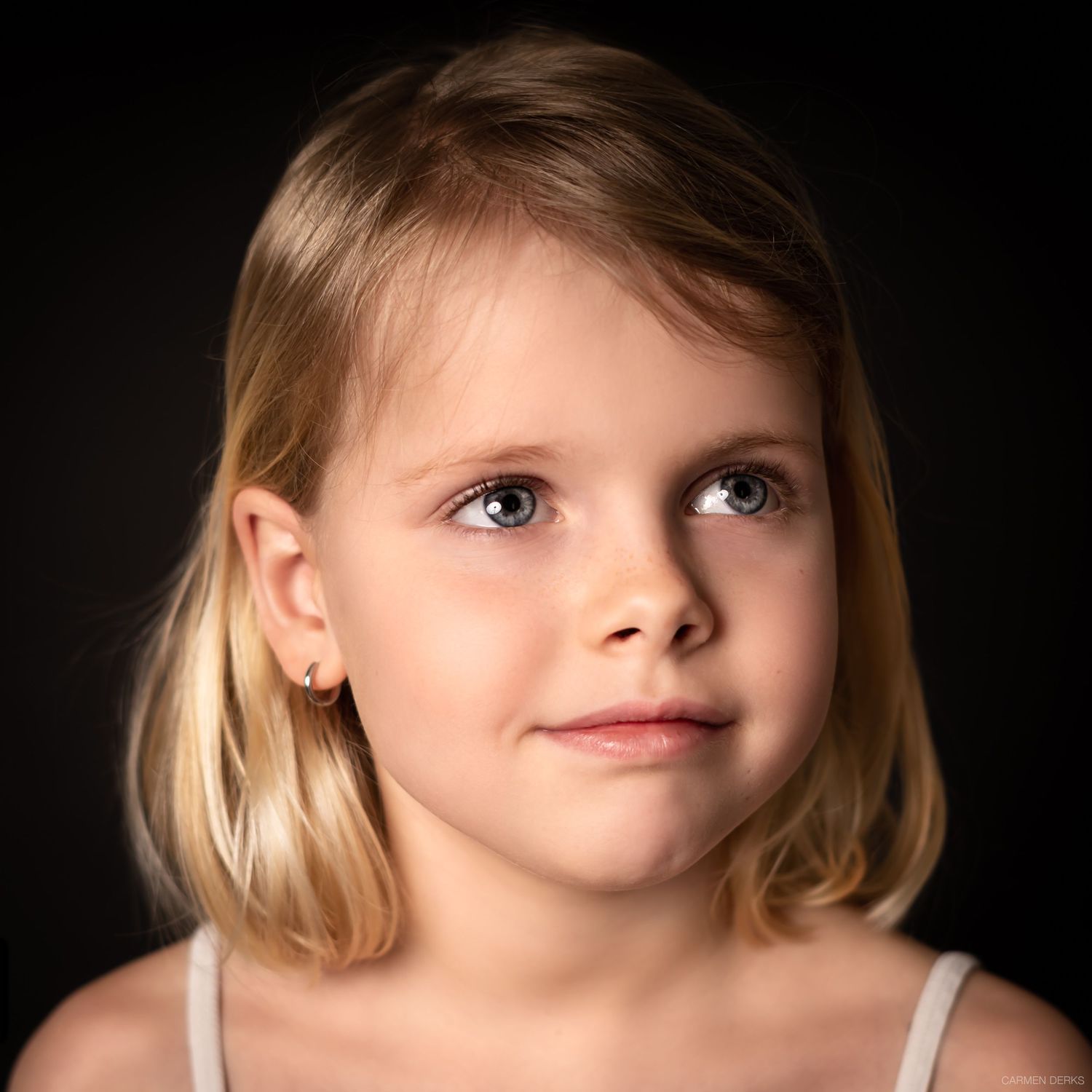 Een professioneel studioportret met een focus op expressie en belichting, vastgelegd tegen een zwarte achtergrond. in Beneden-Leeuwen