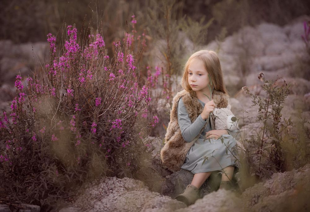 child's photo session sitting on the rocks with the flowers during the sunset in the park in Vaughan, Ontario