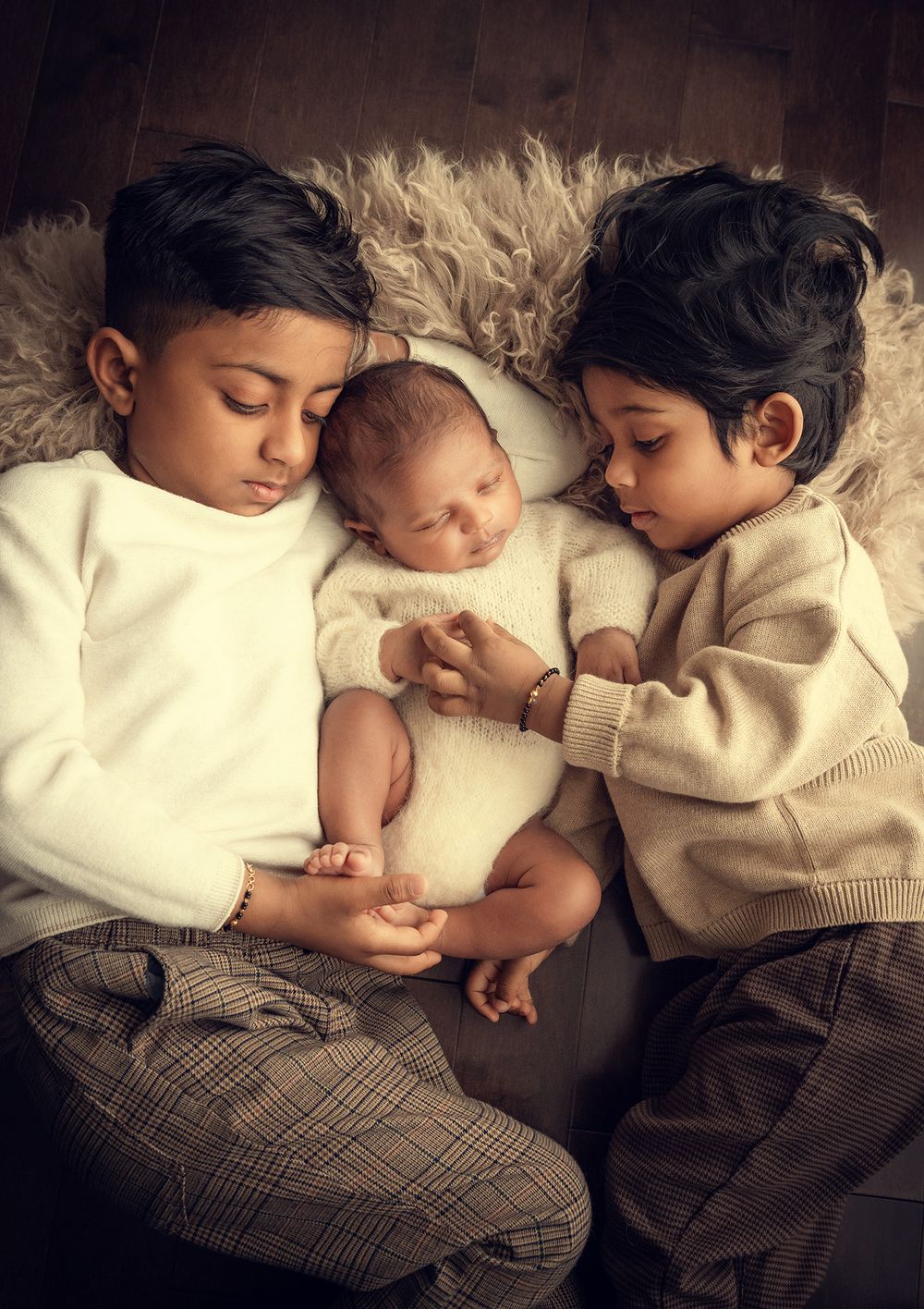 newborn baby photo session with two older brothers snuggling on the rug during the at home photoshoot in Vaughan