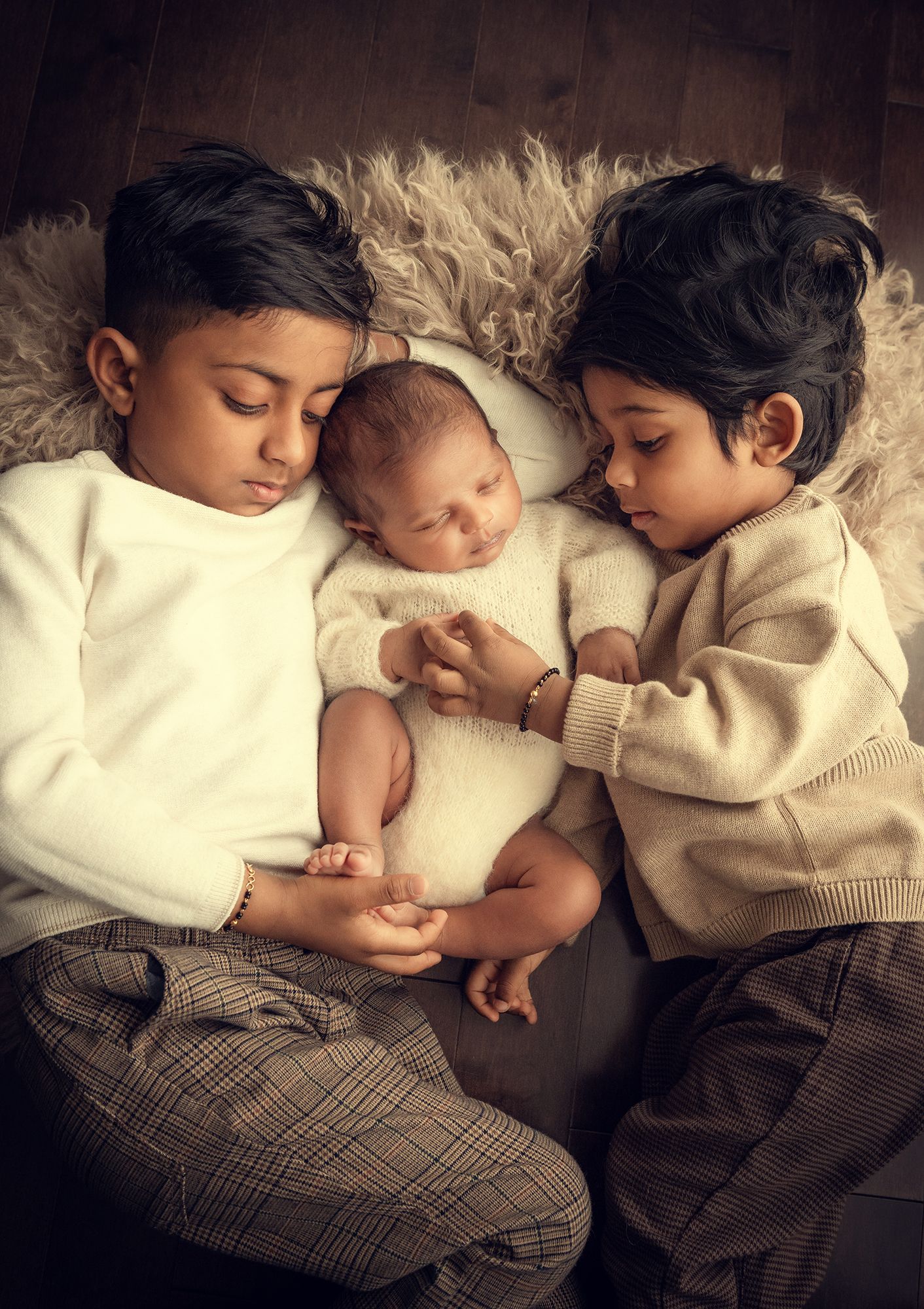 newborn baby photo session with two older brothers snuggling on the rug during the at home photoshoot in Vaughan