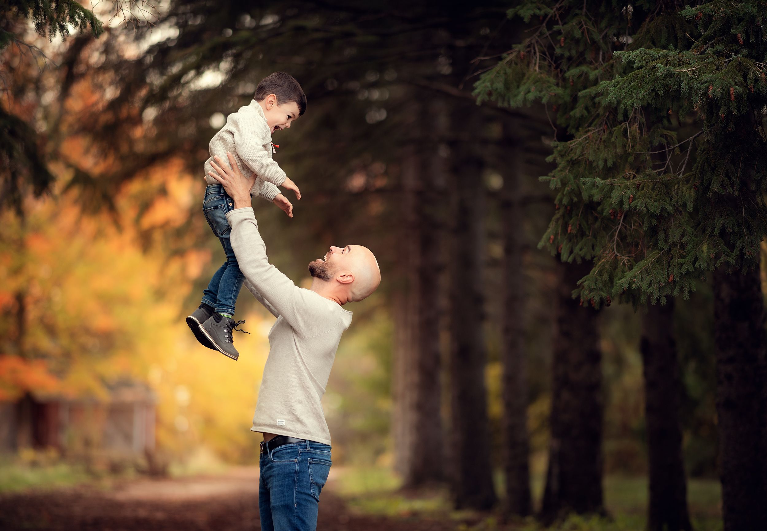 the dad is throwing the kid in the air during the family photoshoot in Kleinburg, Ontario
