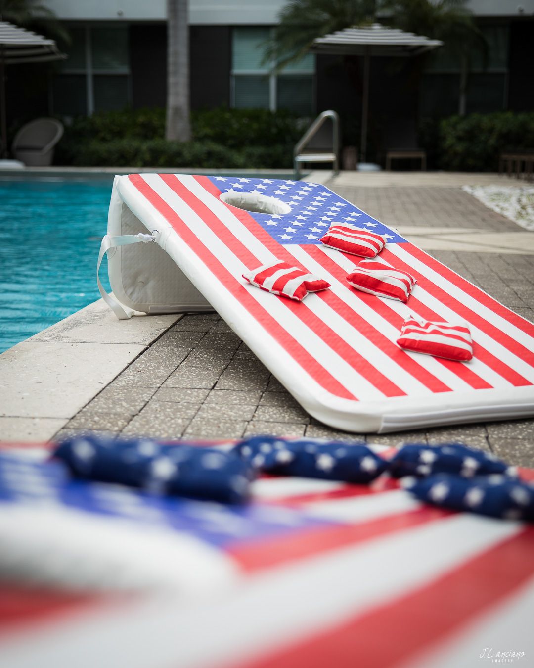 American flag pool float next to swimming pool with patriotic decor.