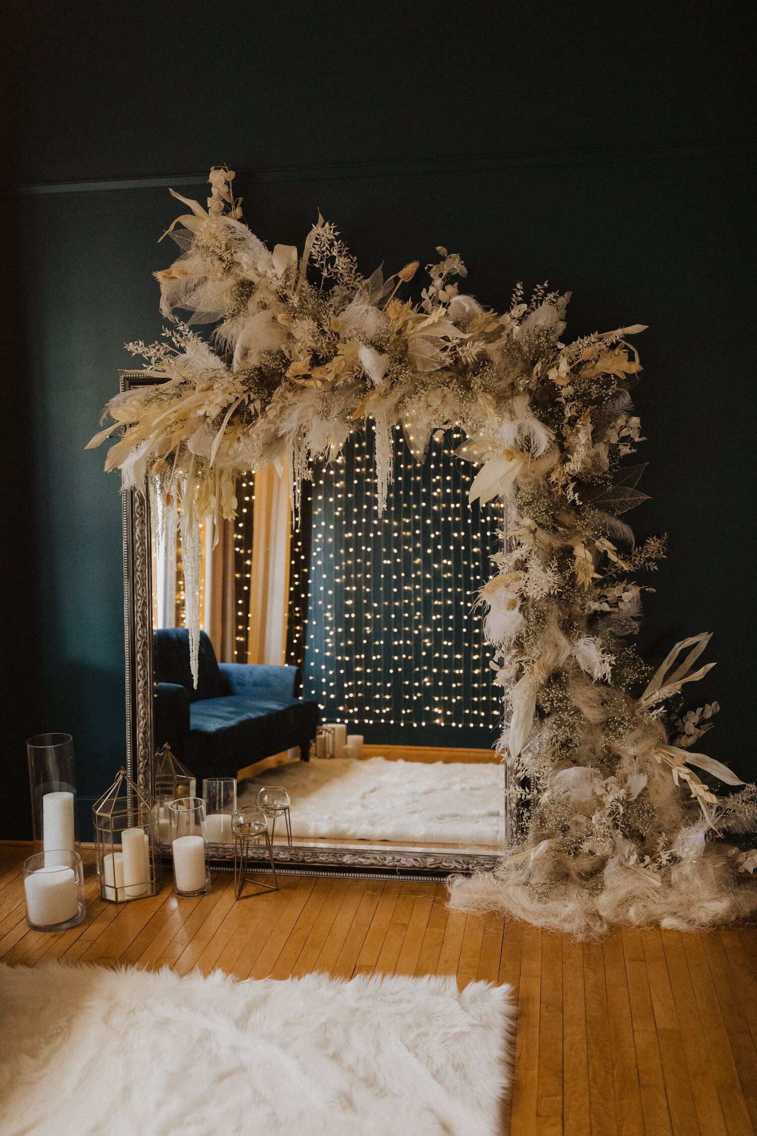 Elegant photo backdrop with fairy lights and dried floral arrangements in neutral tones.