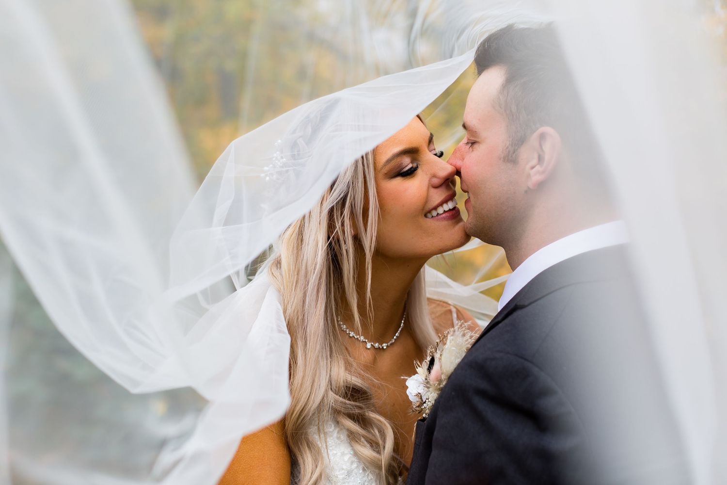 Romantic moment captured through flowing white veil.
