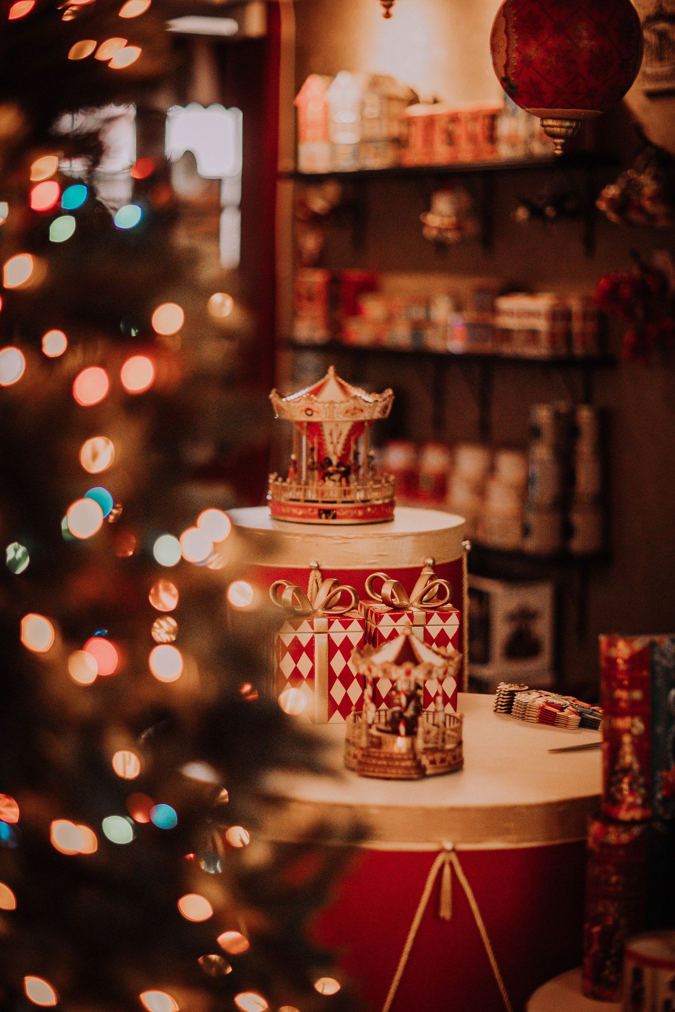 Miniature carousel decoration displayed with festive Christmas lights and bokeh in the background.