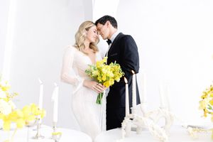 A romantic wedding scene with a bright yellow and white floral display illuminated in natural light.