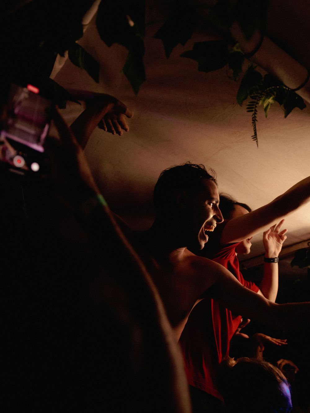 Silhouetted figure dancing energetically in atmospheric club lighting.