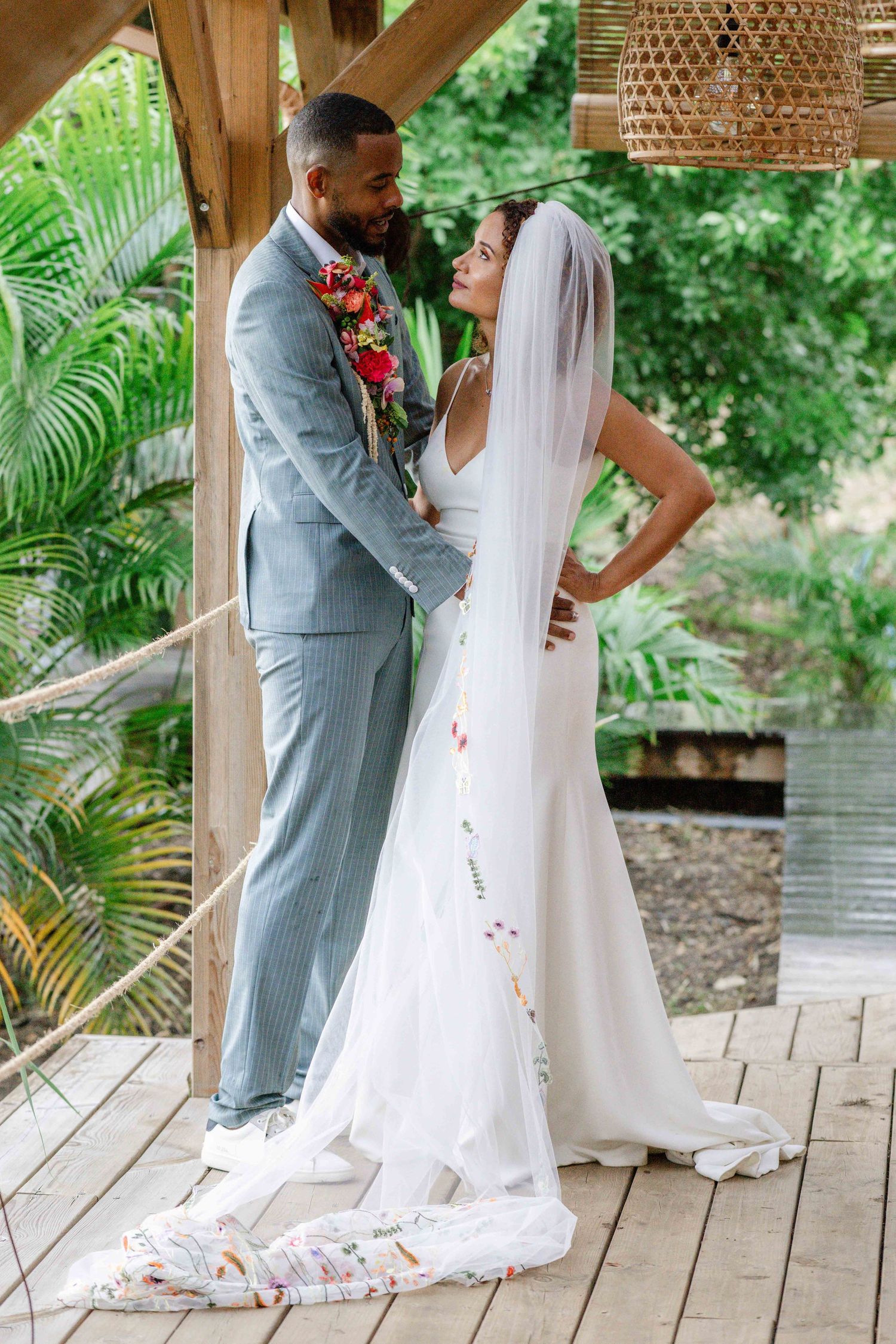 Couple de mariés de profil la mariée à un voile et le marié la regarde.Mariage romantique en Guadeloupe.