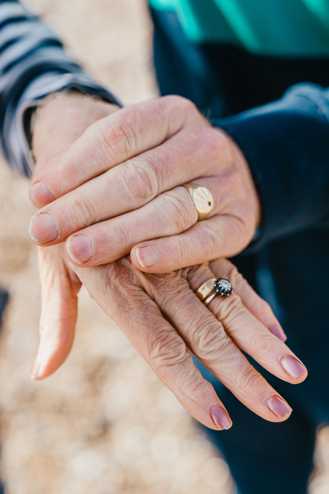 Close-up of hands wearing wedding rings against a blurred background, highlighting love and commitment.