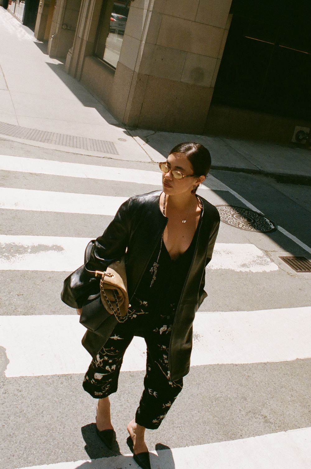 Series of fashion shots showing a person in black clothing walking on an urban street.
