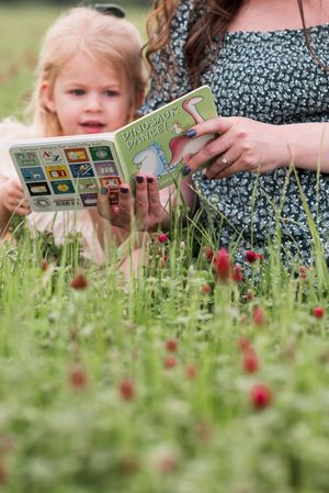 Looking at pictures together among wildflowers in a spring meadow.