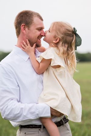 A tender moment shared between parent and child in a grassy field.