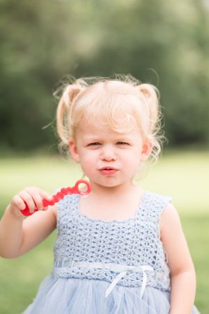 Sweet outdoor portrait showing a light blue dress and playful expression.