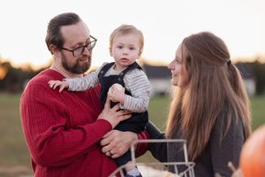 A family shares a tender moment together outdoors during golden hour sunset.