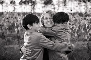 A series of black and white photos showing people embracing outdoors in candid emotional moments.