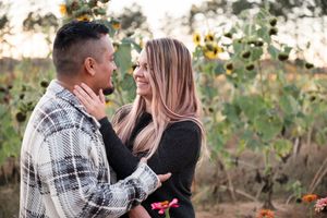 A couple shares tender moments during a fall photoshoot with plaid and earth-toned clothing.