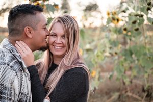 Intimate moment between couple sharing affection among wildflowers at dusk.