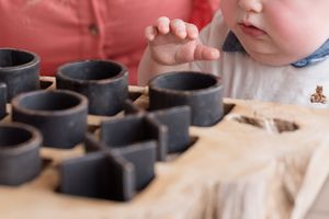 Close-up view of hands shaping clay on a pottery wheel while creating a ceramic vessel.