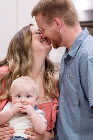 Intimate family moment captured in a series of tender interactions in a light indoor setting.